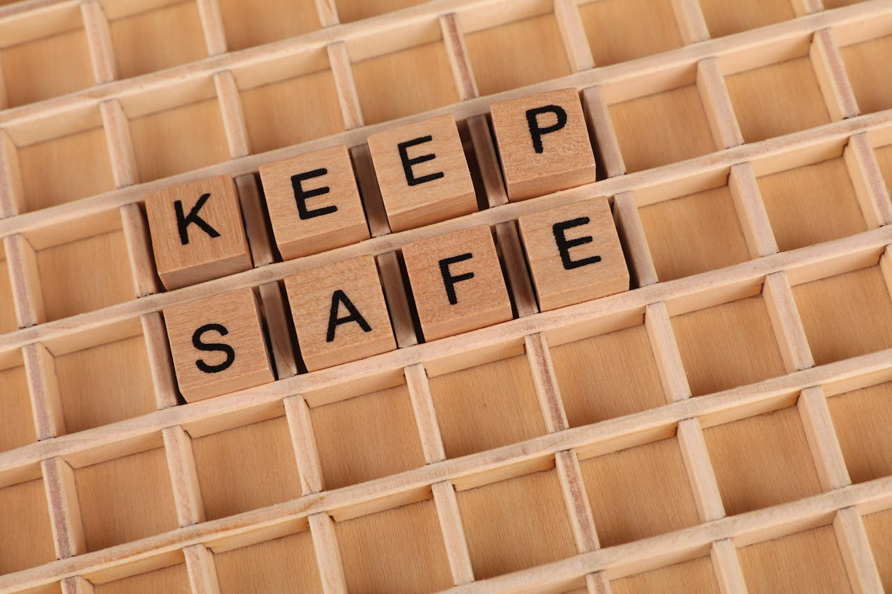 Wooden blocks spelling "Keep Safe" on a grid background. Ideal for messages of security and care.